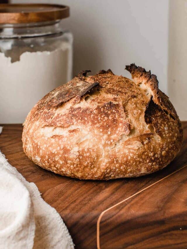 A loaf of sourdough bread on a cutting board.