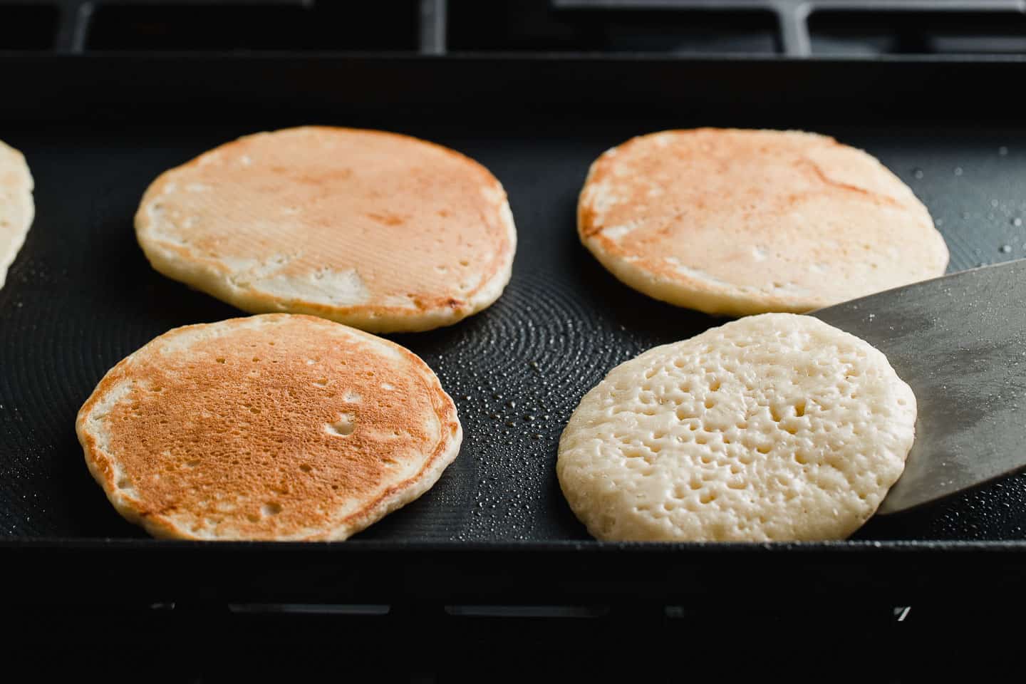 Flipping sourdough pancakes on a griddle.