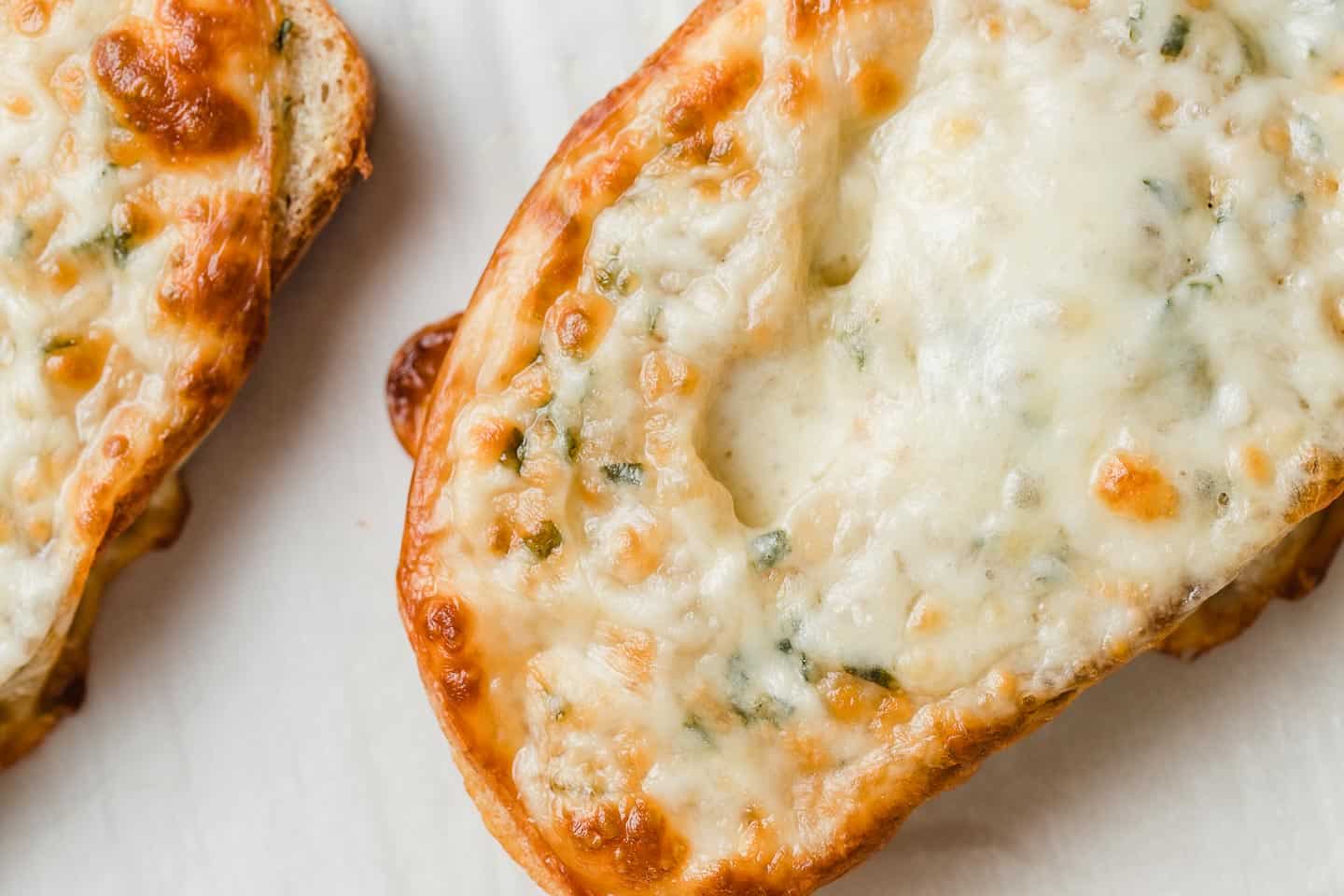 A closeup picture of garlic herb cheesy bread.