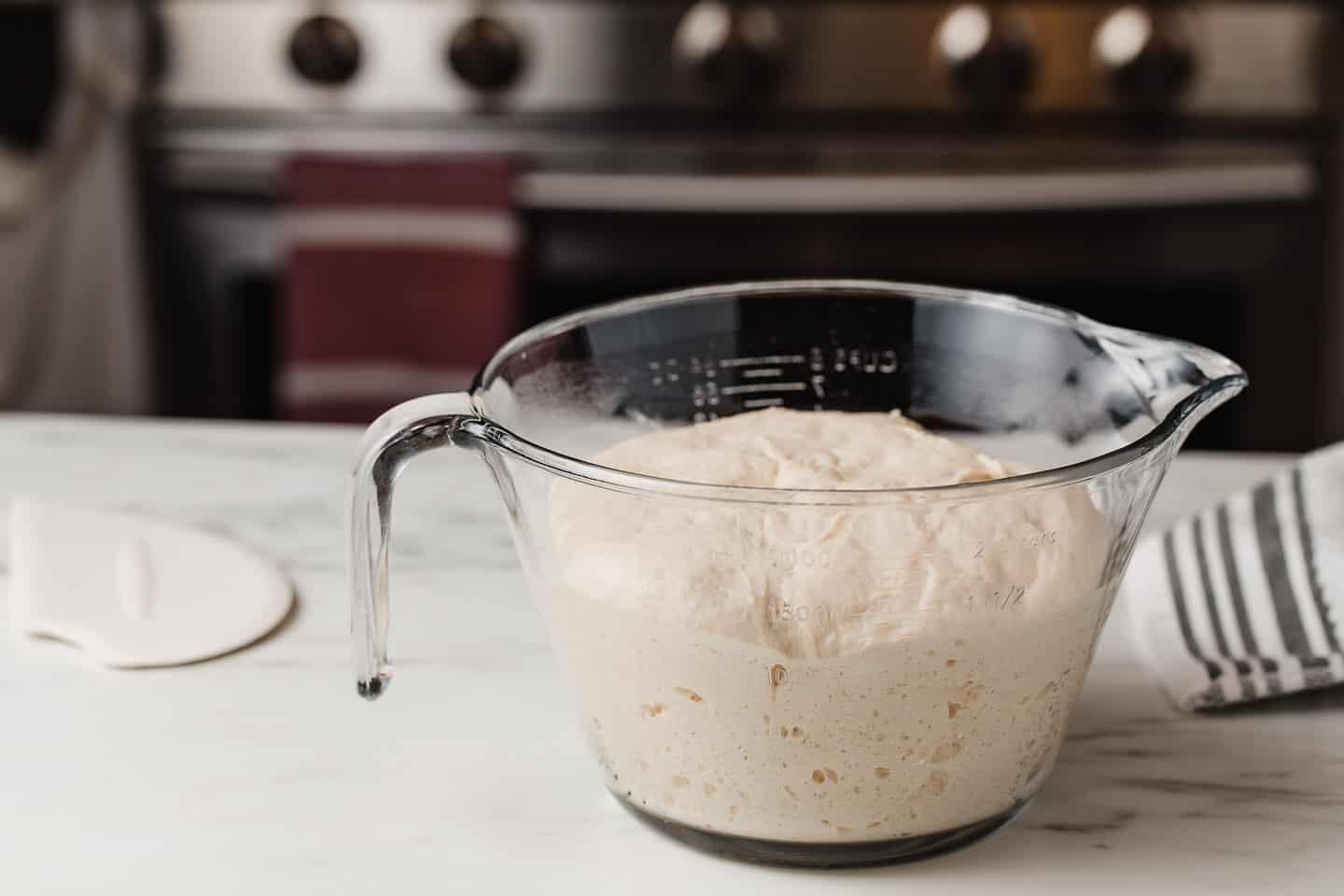 A bowl of fermented dough on a kitchen counter.