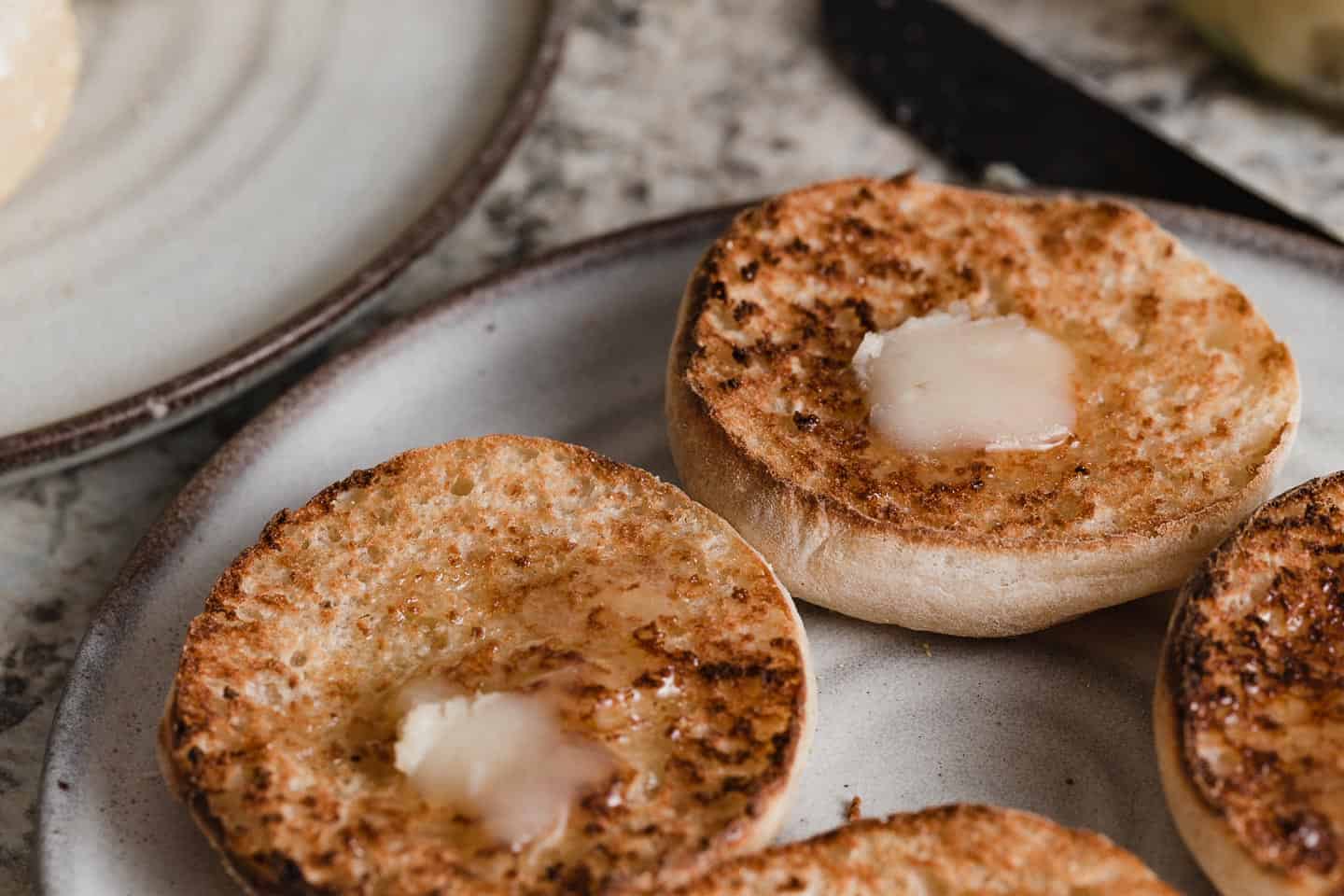 Sourdough english muffins toasted with melted butter on top.