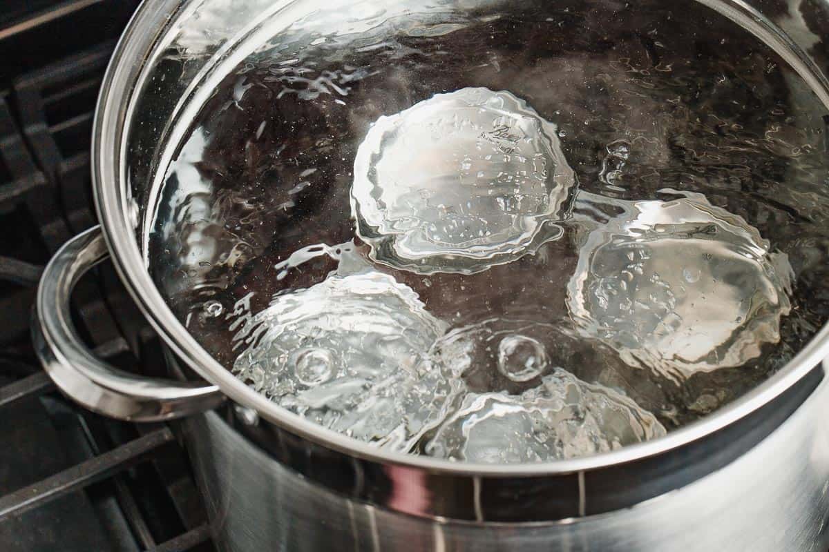 Jars in a water-bath canning with boiling water.