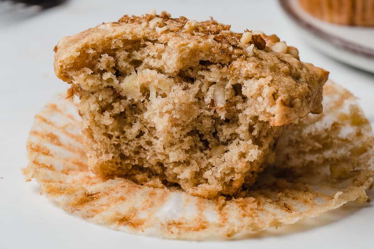 A sourdough banana nut muffin with a bite taken out.
