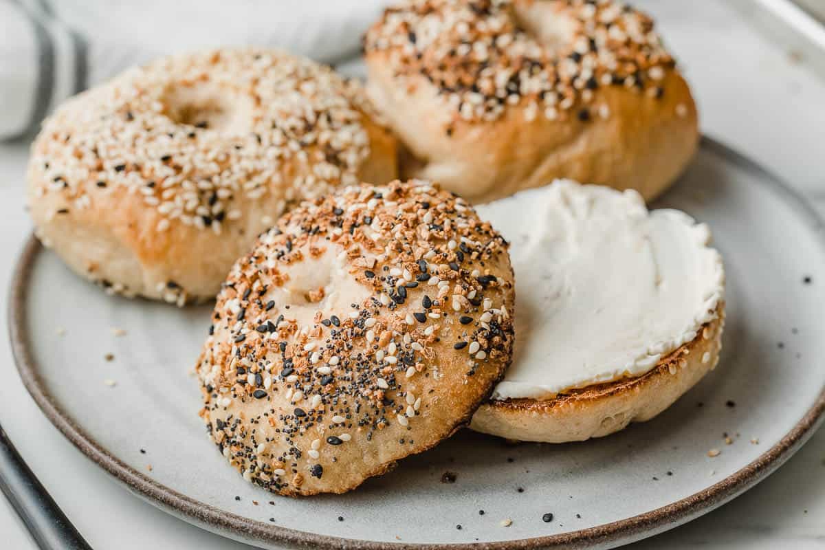 Sourdough bagel on a plate with cream cheese.