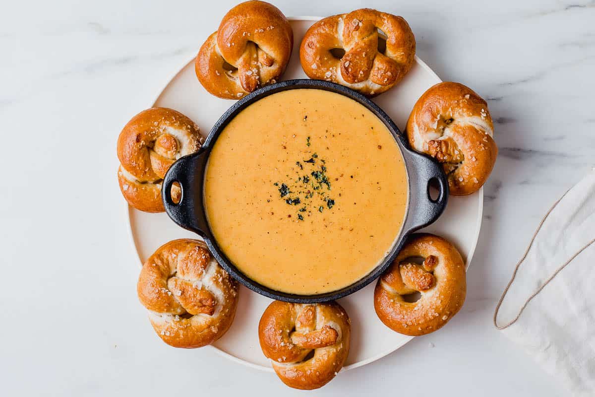 Beer cheese dip in a bowl with sourdough pretzels.