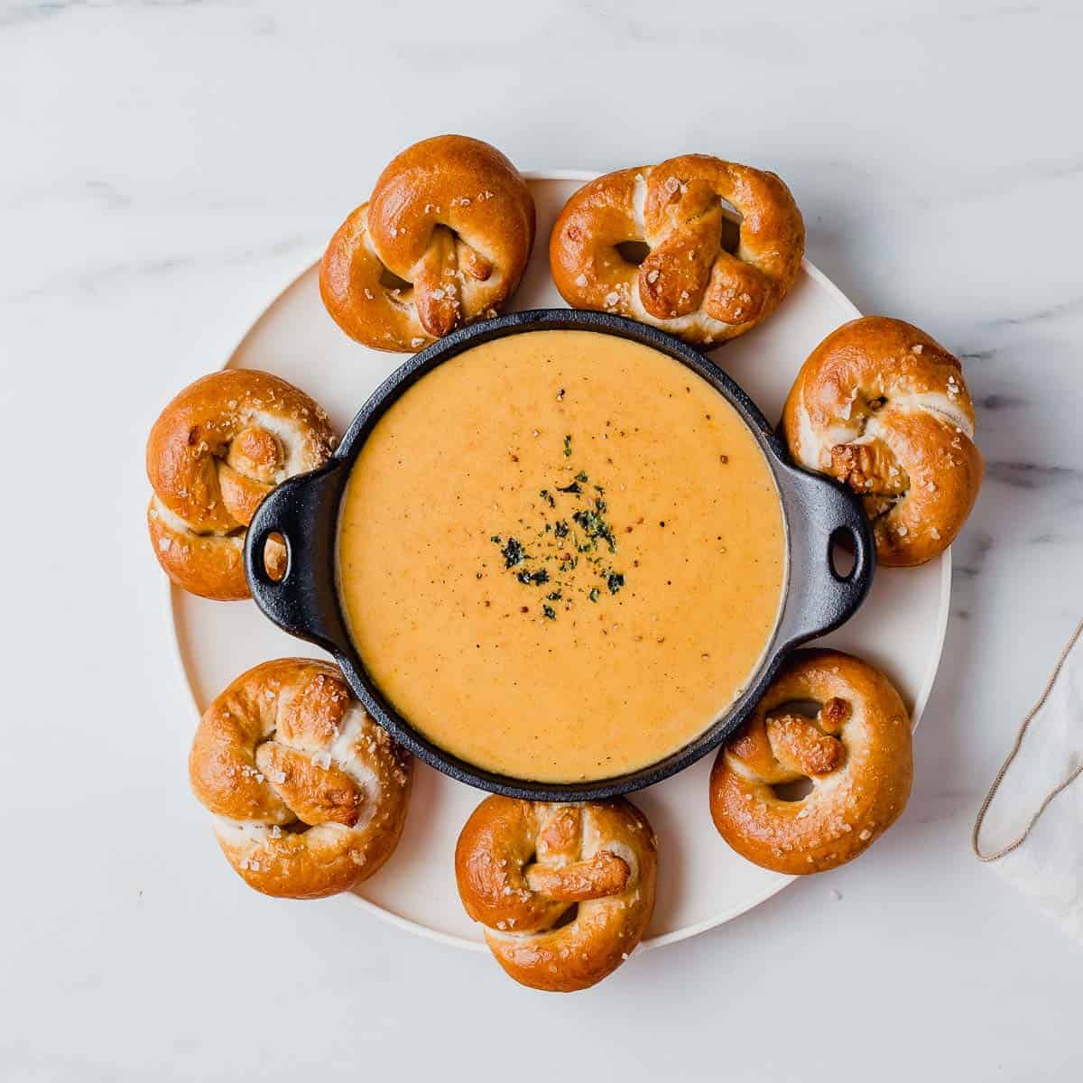 Beer cheese dip on a platter with pretzels.