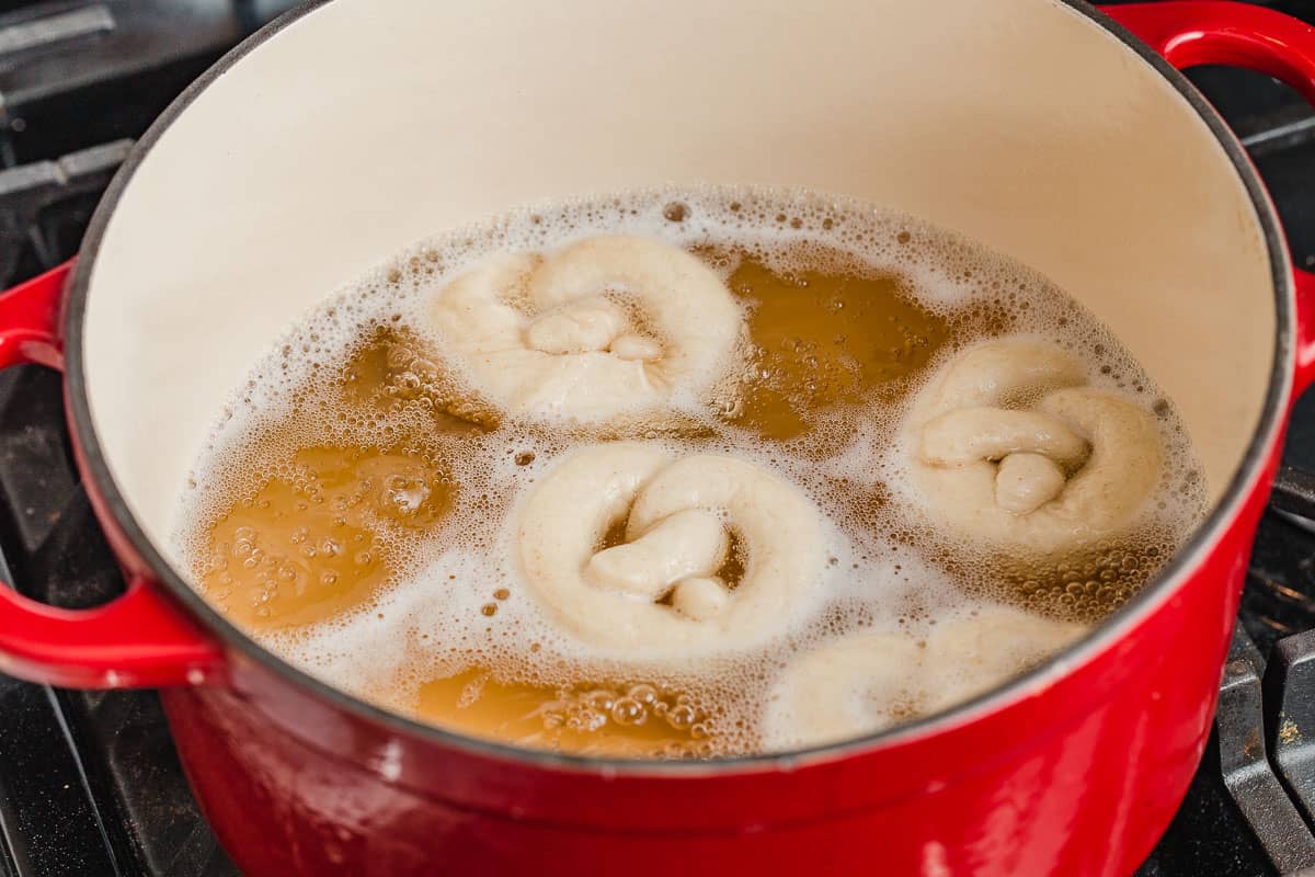 A pot of boiling water with pretzel dough.