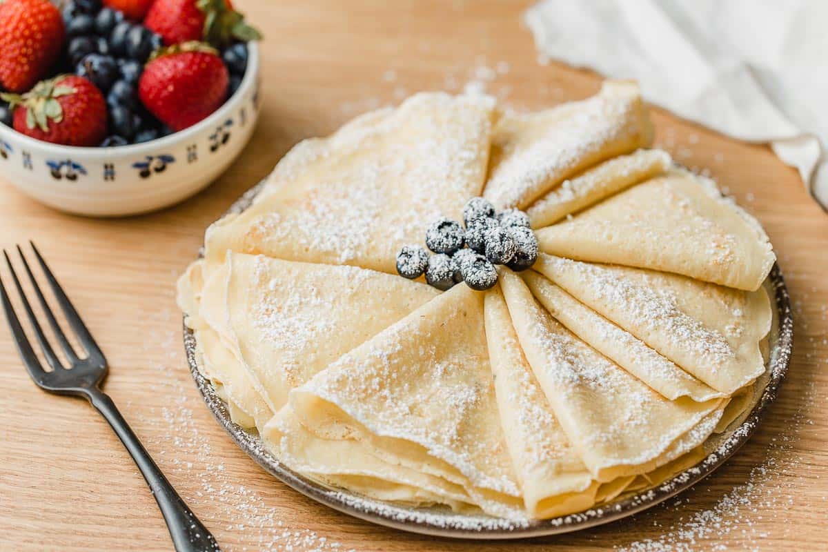 Sourdough crepes folded into quarters and sprinkled with powdered sugar.
