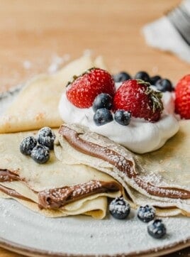 Sourdough crepes on a plate with nutella and berries.