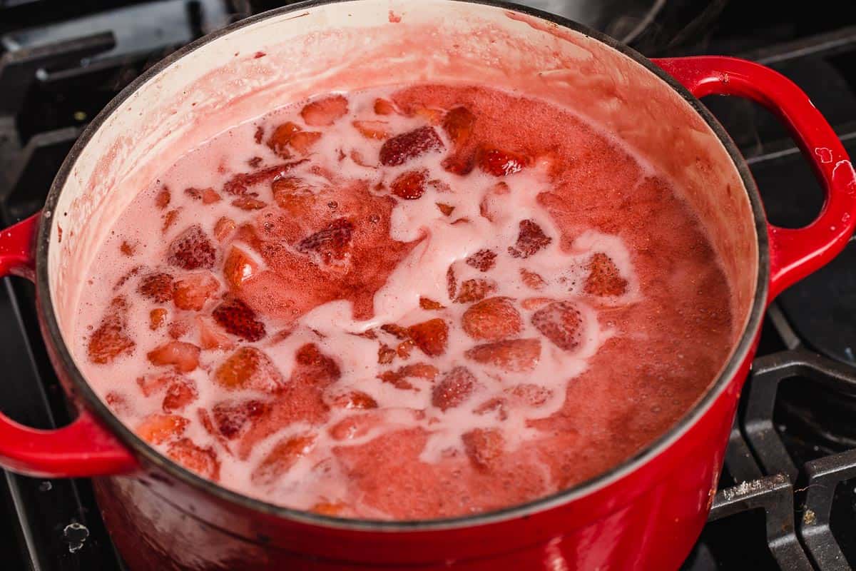 Strawberry jam cooking in a stockpot.