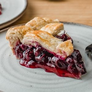 A slice of blueberry pie on a plate.