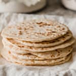 A stack of sourdough tortillas on a plate.
