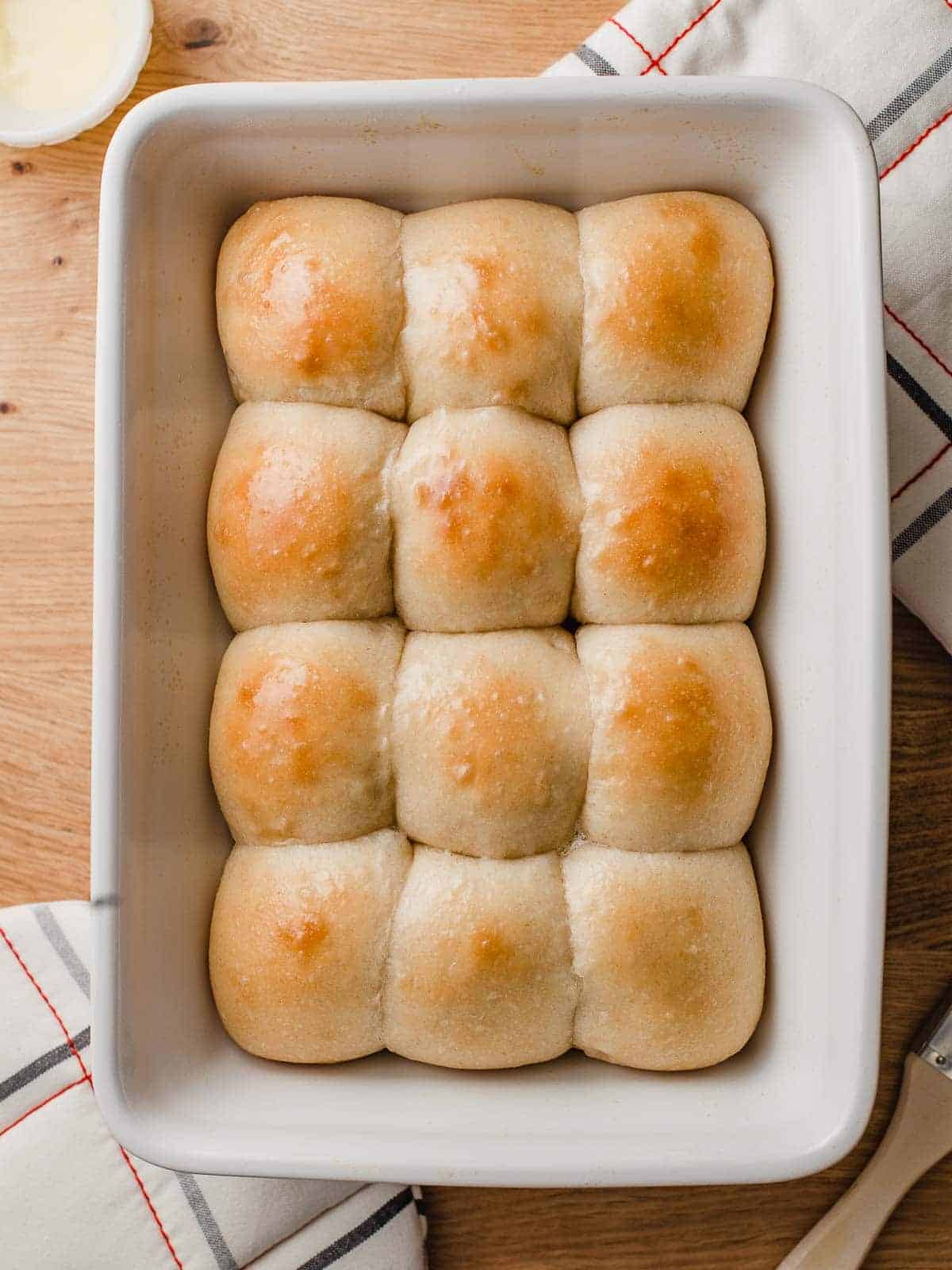 Soft sourdough dinner rolls in a baking dish.