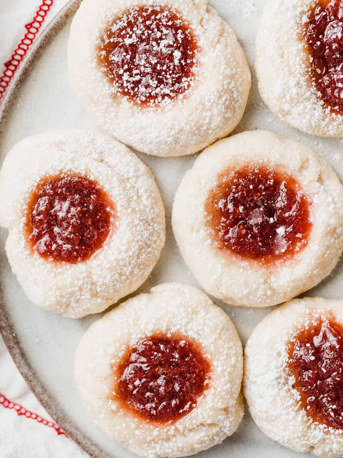 Baked sourdough thumbprint cookies on a plate.