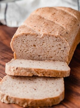 A loaf of gluten free sourdough bread on a cutting board.