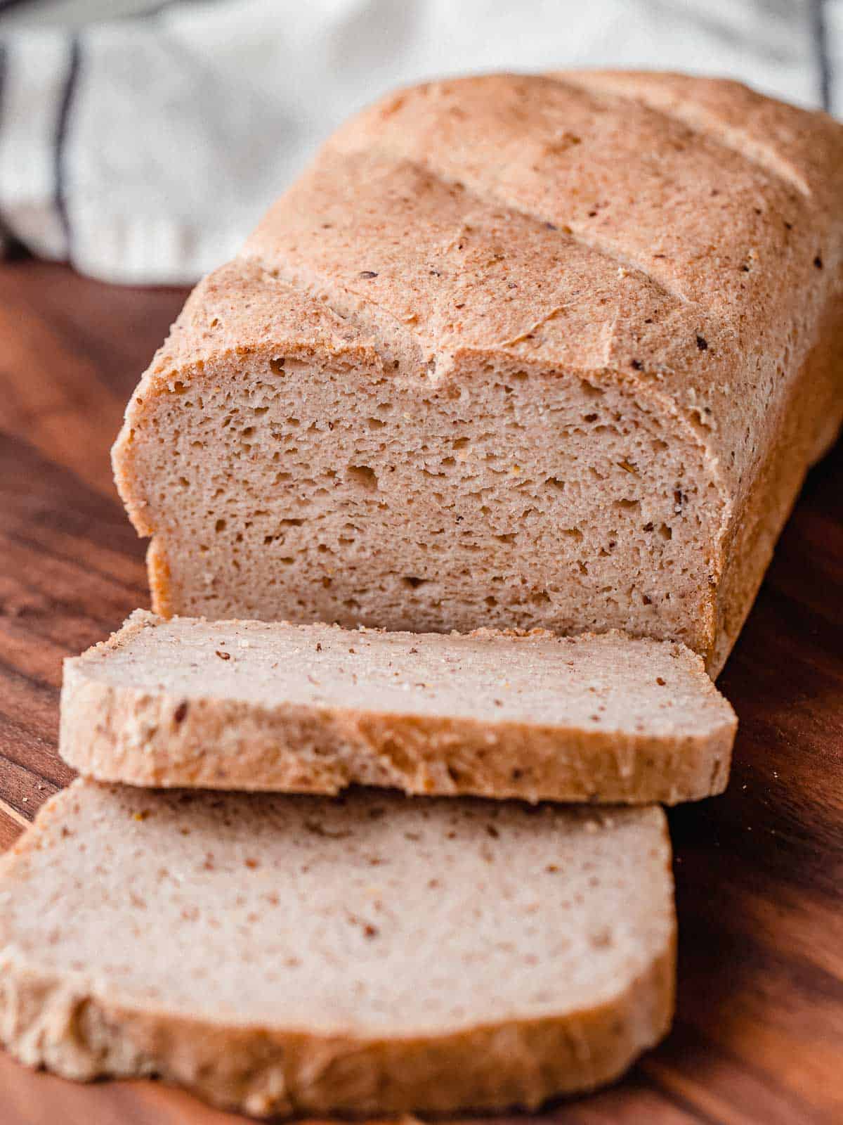 A loaf of gluten free sourdough bread on a cutting board.