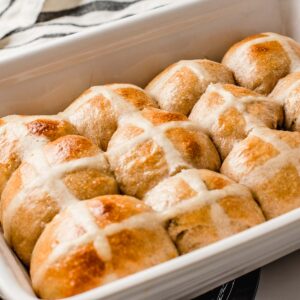 Sourdough hot cross buns in a baking dish.
