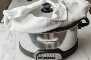 A towel placed under the lid of the slow cooker.