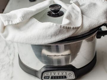 A towel placed under the lid of the slow cooker.