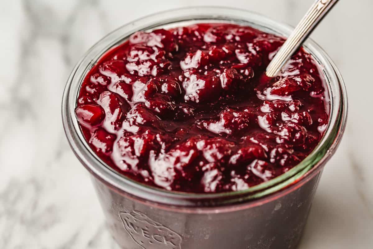 A closeup photo of cherry jam in a weck jar.