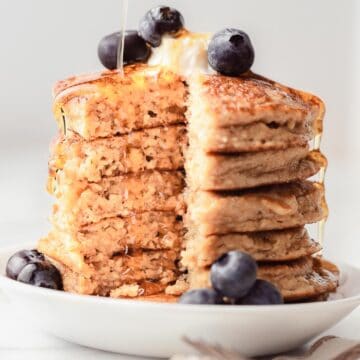 A stack of pancakes with blueberries and syrup.