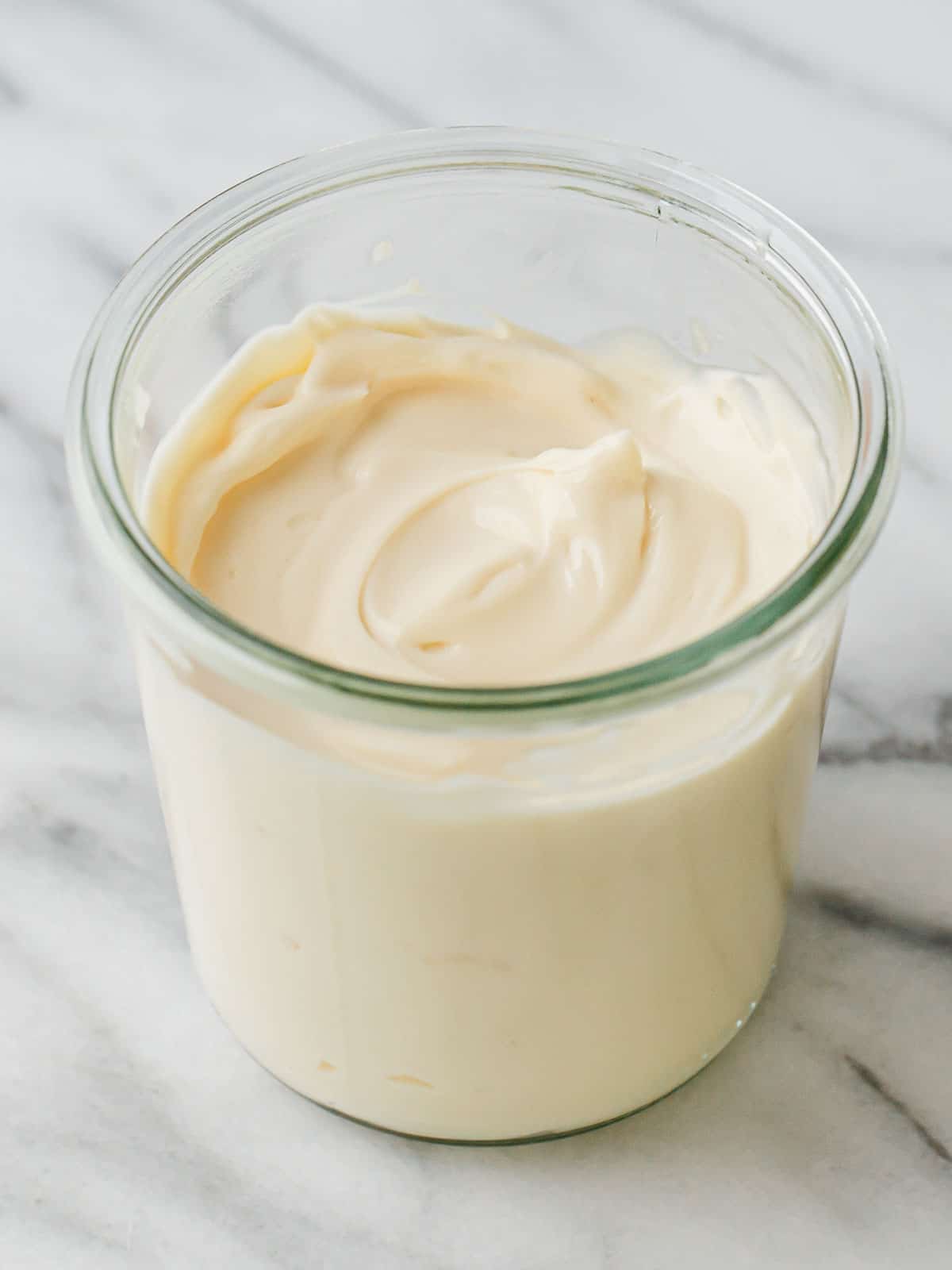 Homemade mayonnaise in a glass jar.