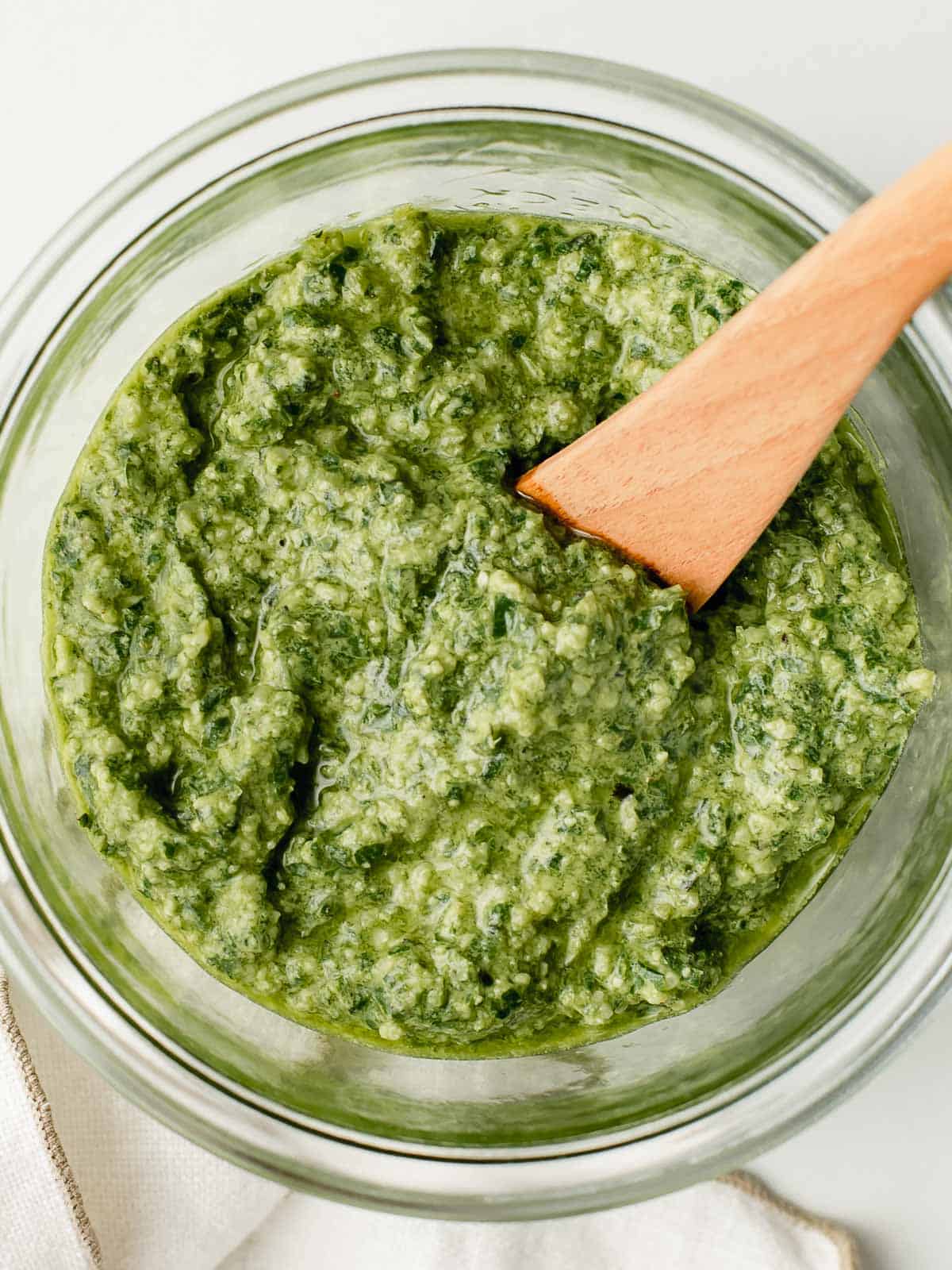 Top view of basil pesto in a glass jar.