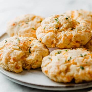 Cheddar bay biscuits stacked on a plate.