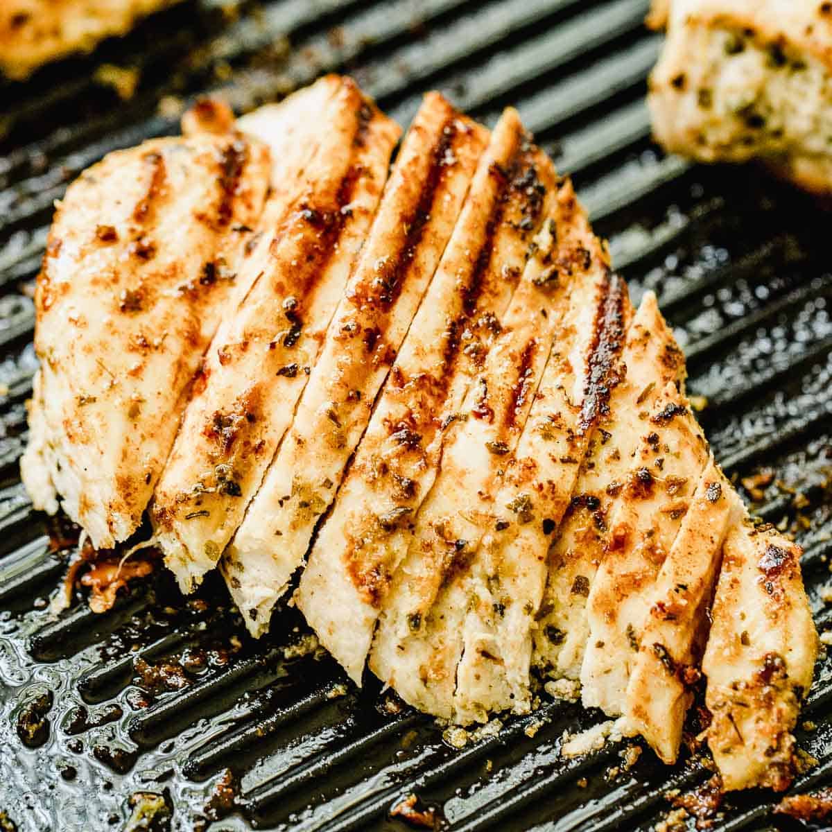 A sliced chicken breast on a grill pan.