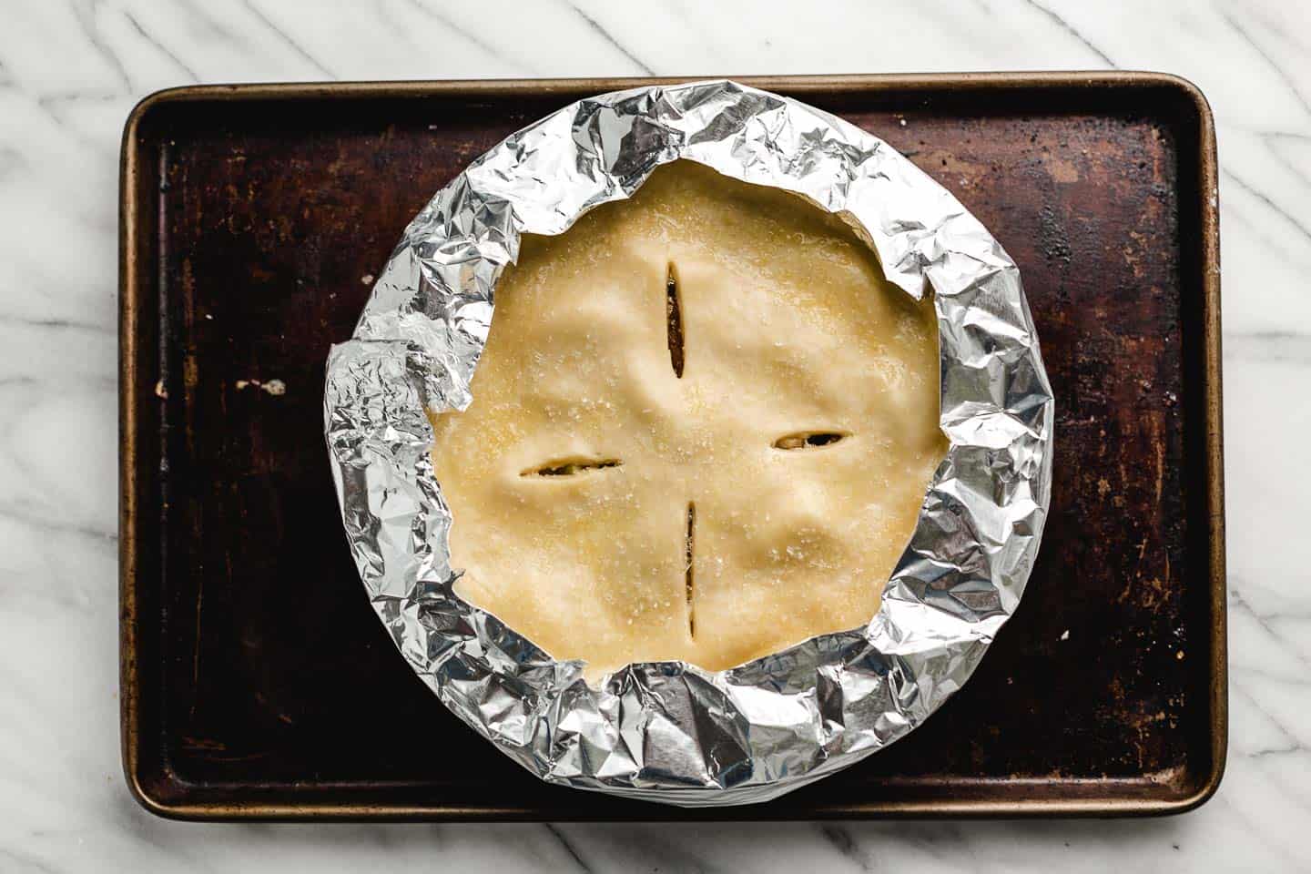 A pie shield on an apple pie.