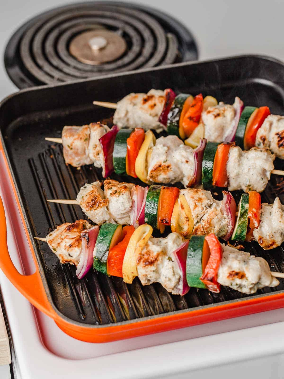 Chicken kabobs on a grill pan.