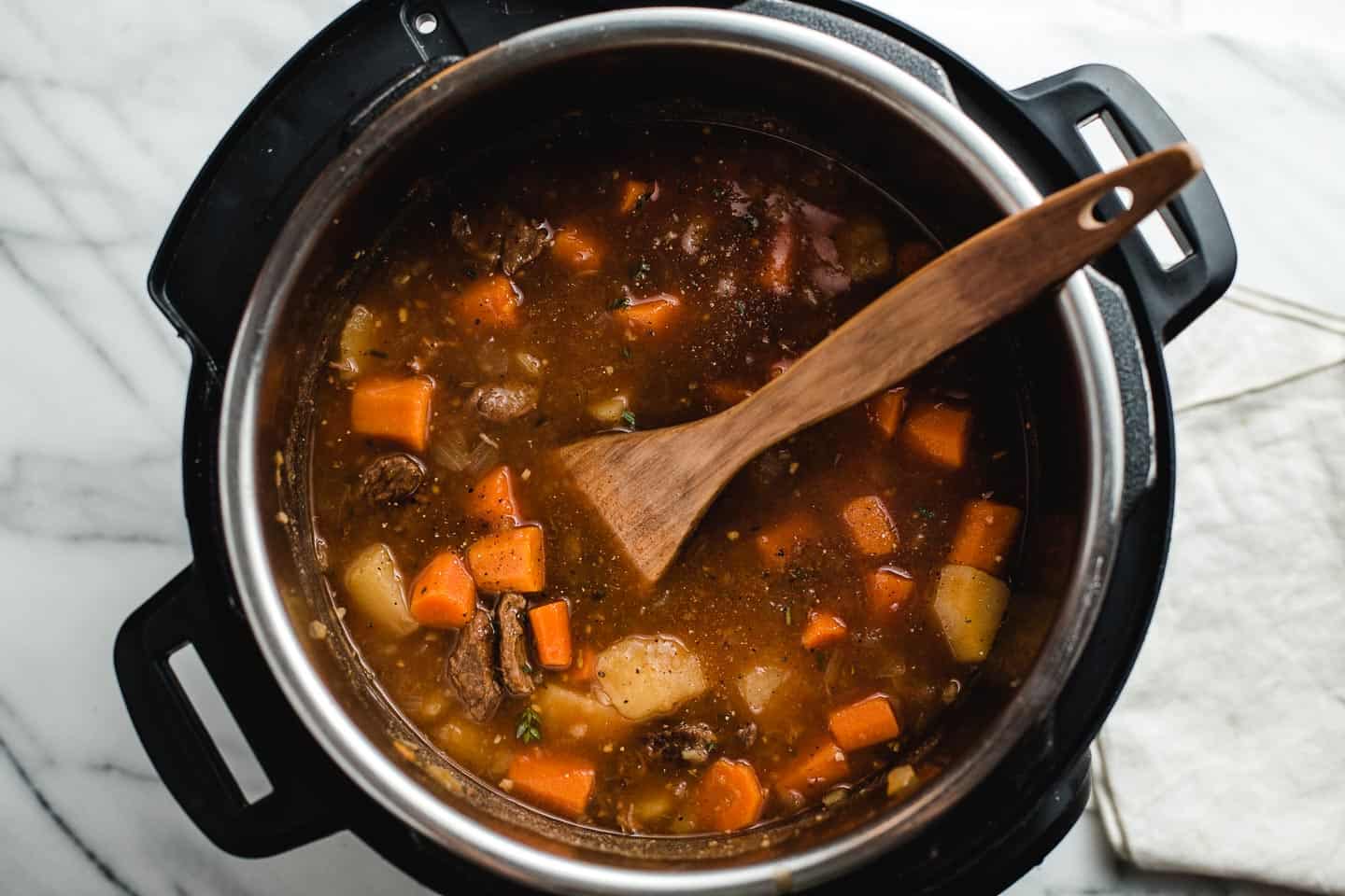 Thickening the stew with a cornstarch slurry.