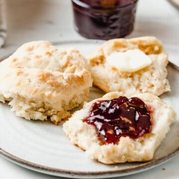 Sourdough biscuits with butter and jam in a plate.