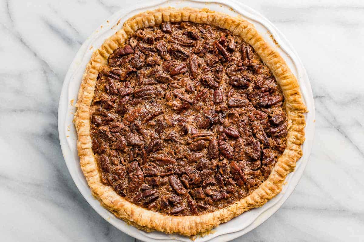 A baked pecan pie cooling on the kitchen counter.