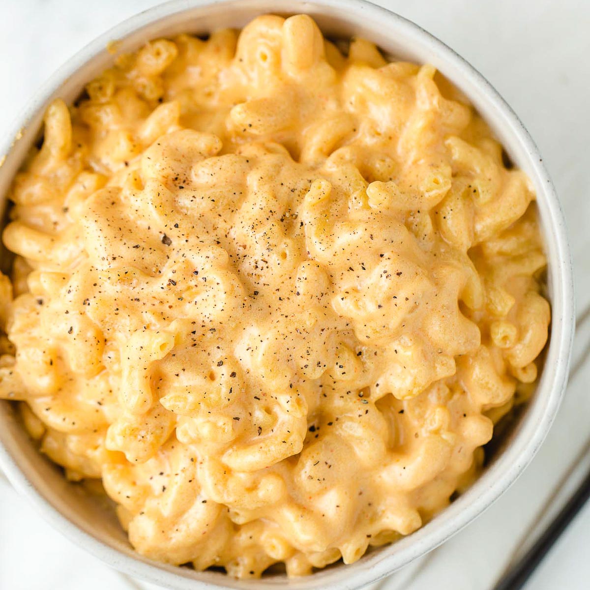 A top view photo of a bowl of mac and cheese.