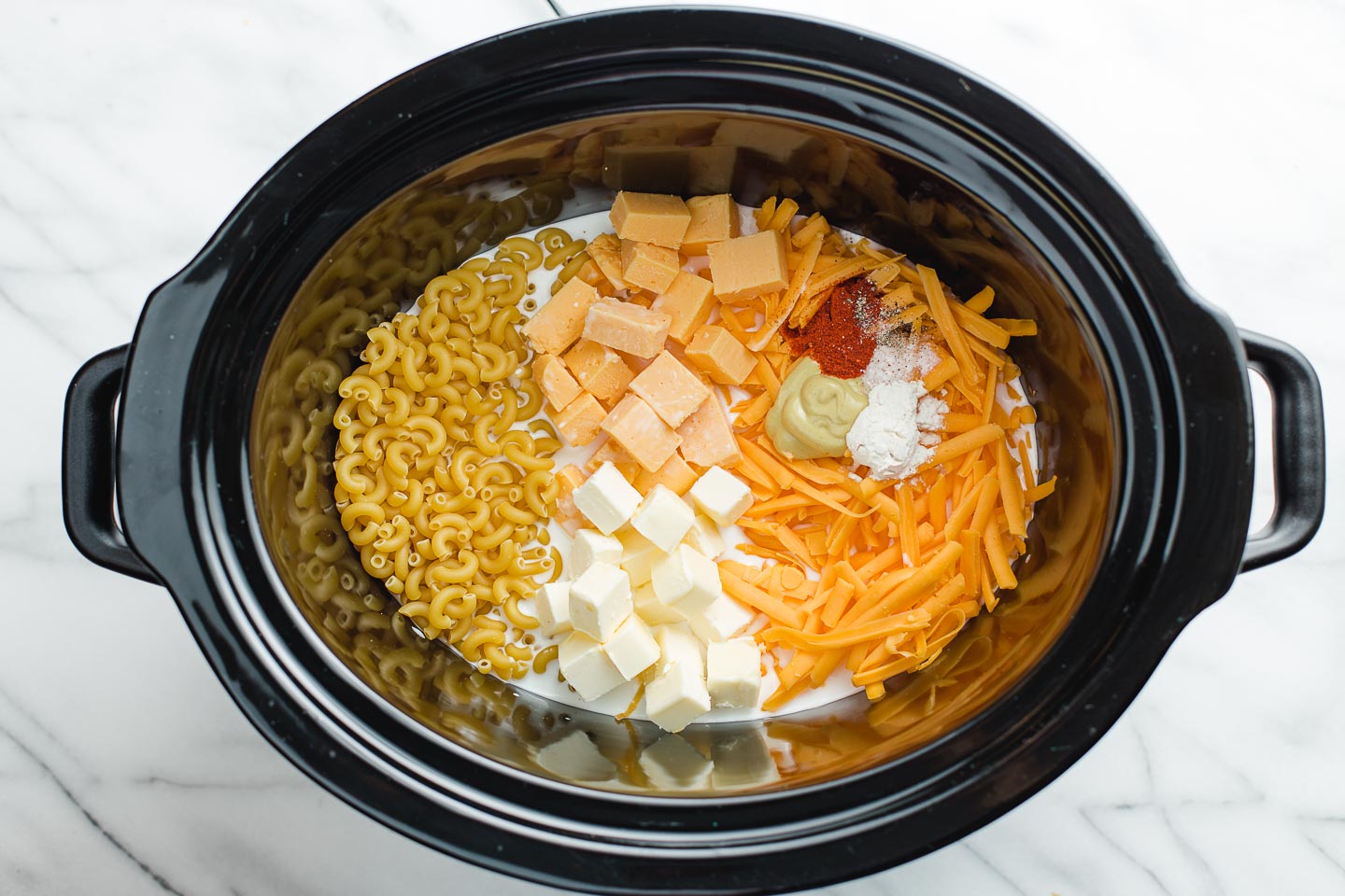 Slow cooker mac and cheese ingredients in a crock-pot liner.