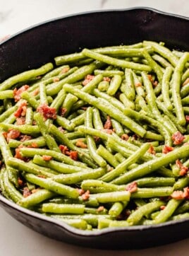 Green beans with bacon in a cast iron skillet.
