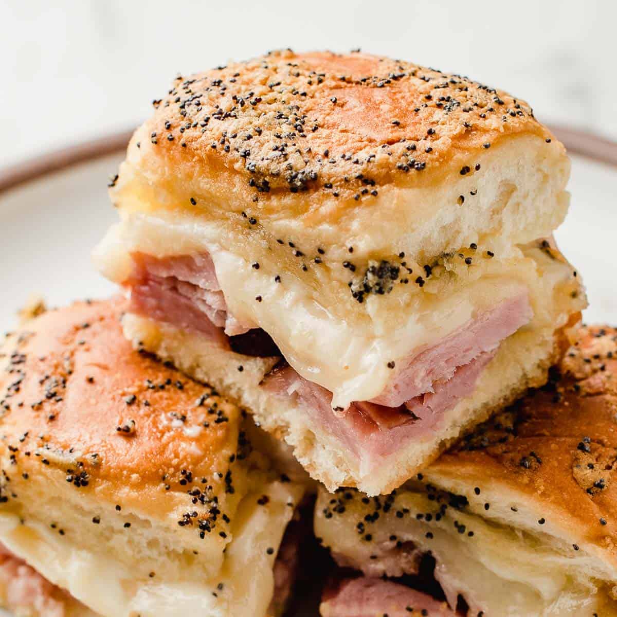 Ham and cheese sliders stacked on top of each other.