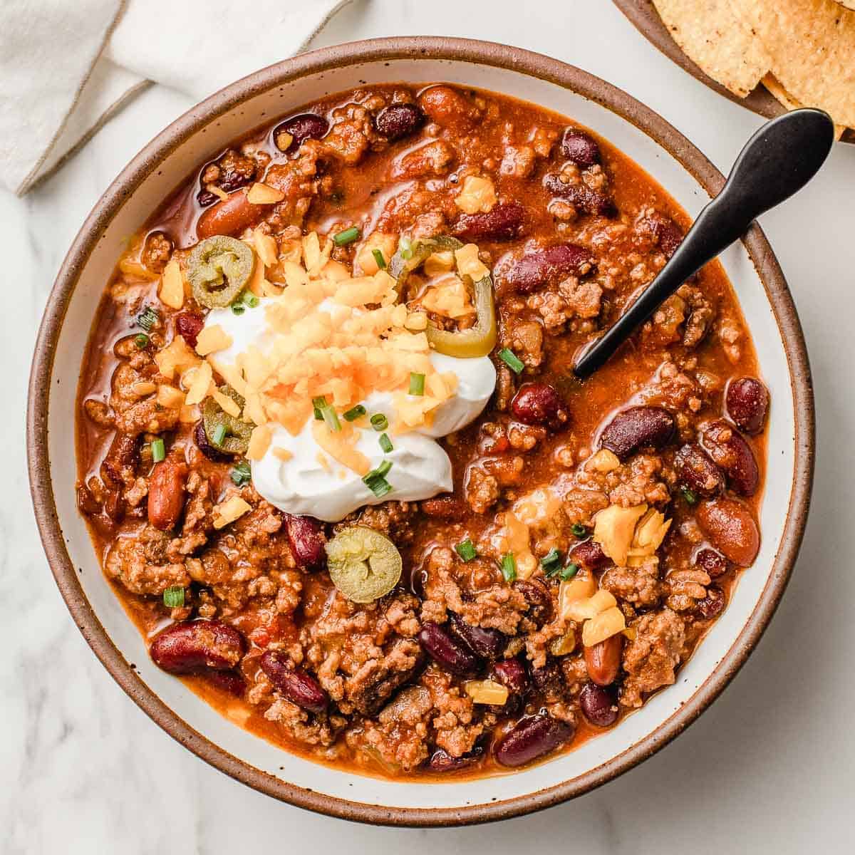 Slow cooker chili in a bowl with toppings.