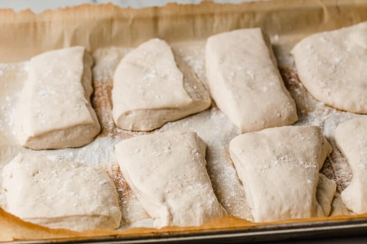 Sourdough ciabatta rolls dough on a baking sheet.