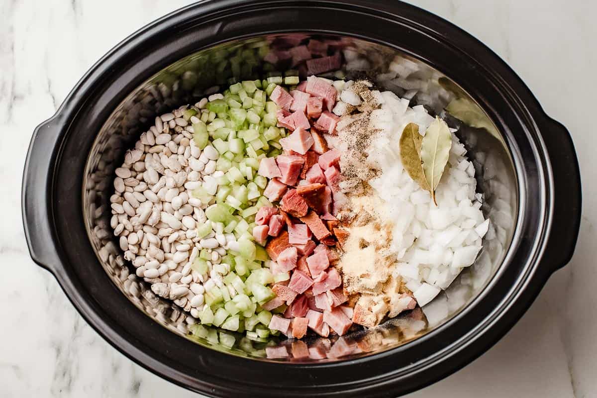 Slow cooker white beans and ham ingredients in the liner.