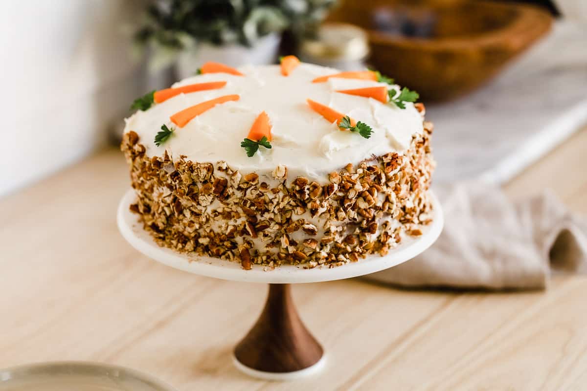 A carrot cake on a cake stand.