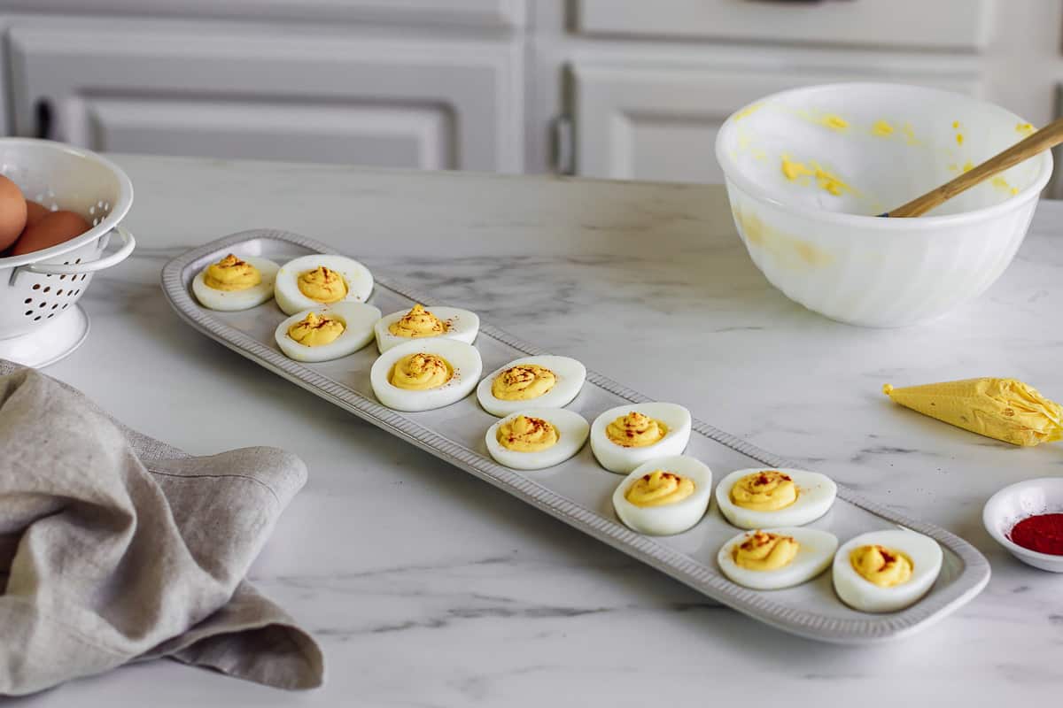 Deviled eggs on a serving platter with paprika.