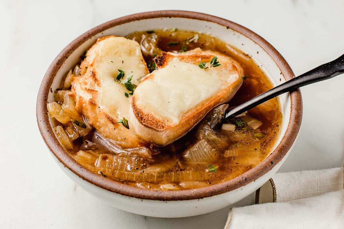 French onion soup in a bowl on a counter.