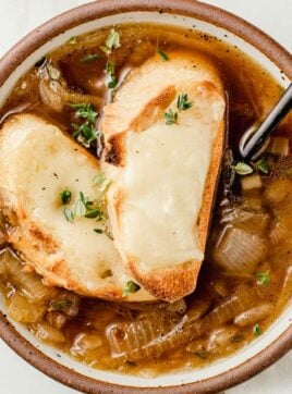 French onion soup in a bowl with cheese croutons on top.