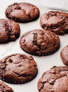 Double chocolate sourdough muffins in a muffin tin.