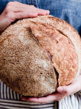Amy Duska holding a loaf of sourdough bread.