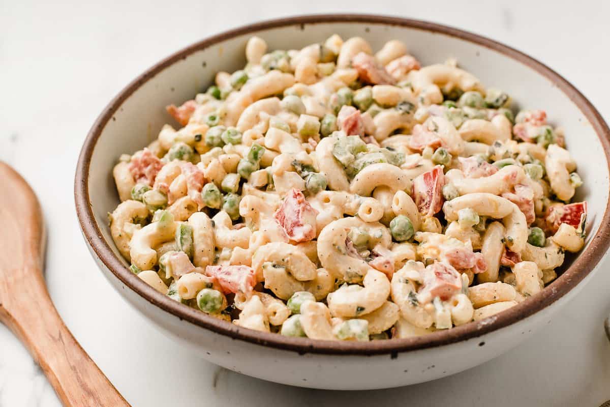 Creamy macaroni salad in a bowl with a spoon.