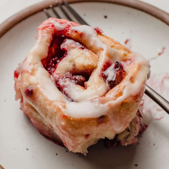 A berry sourdough sweet roll on a plate.
