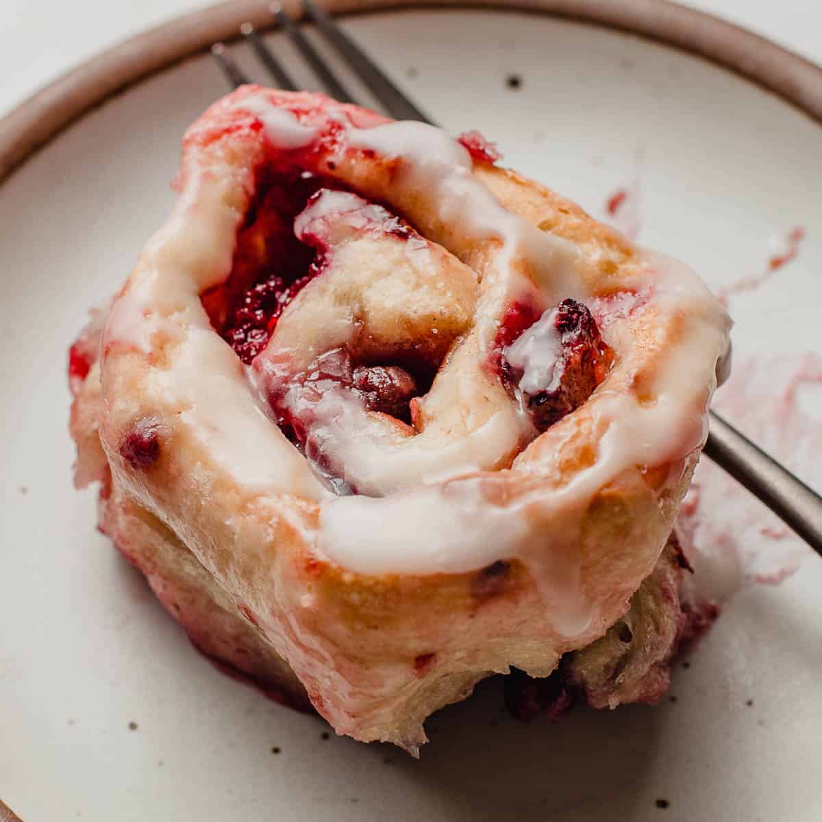 A berry sourdough sweet roll on a plate.
